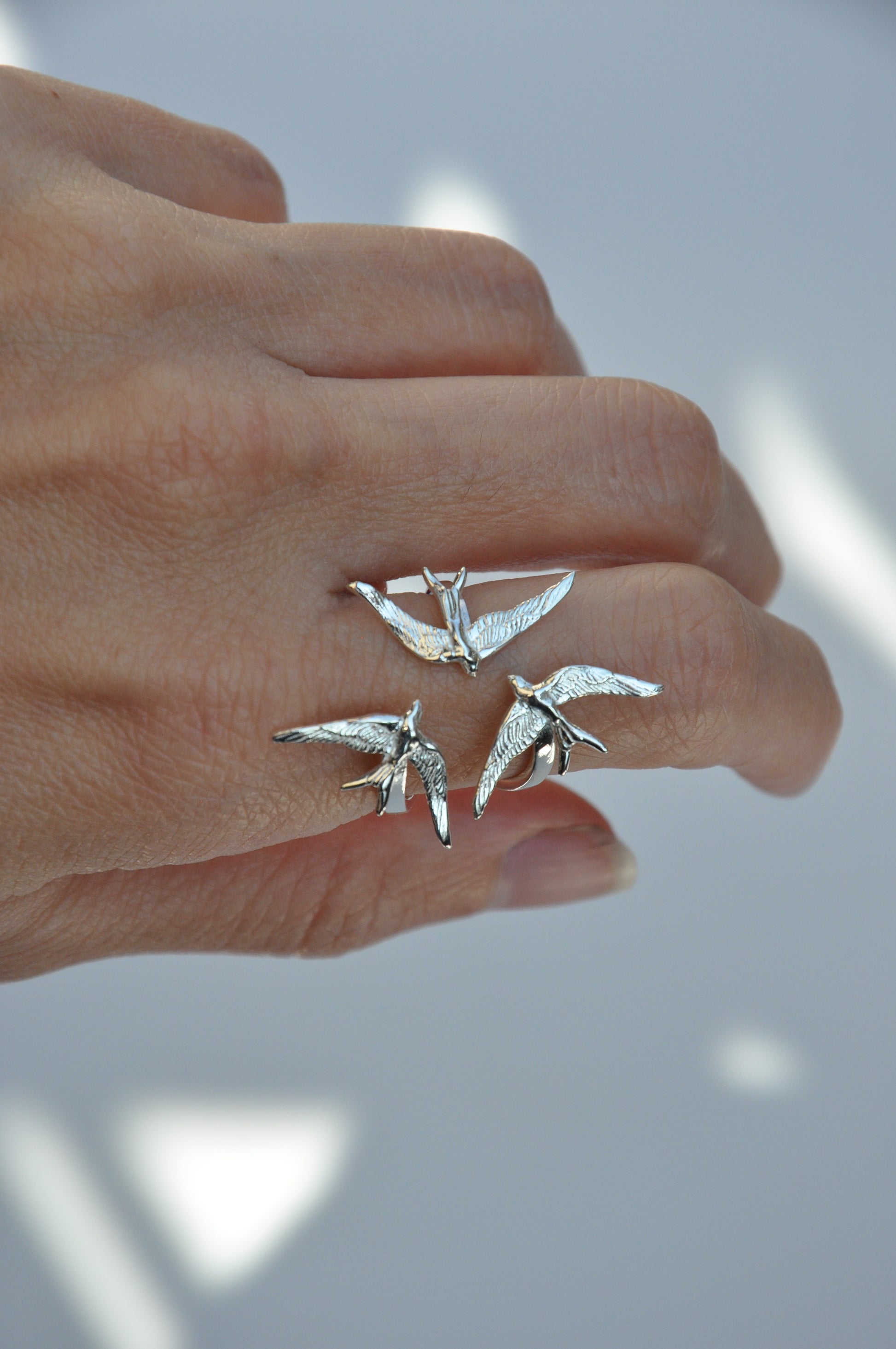 Swallow Gathering Ring worn on hand in silver finish, highlighting the circular motion and sculptural elegance of the design.