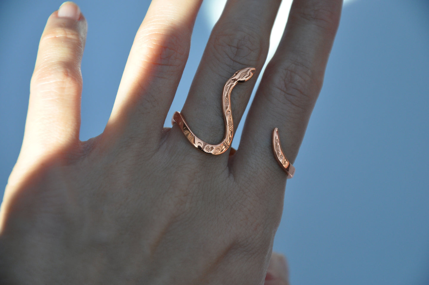 Two-finger celestial snake ring in 14K rose gold plated finish on white background, emphasizing warm metallic tones.