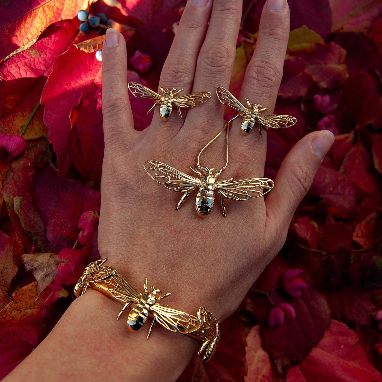 Model wearing silver and gold bee pendant necklace, front view