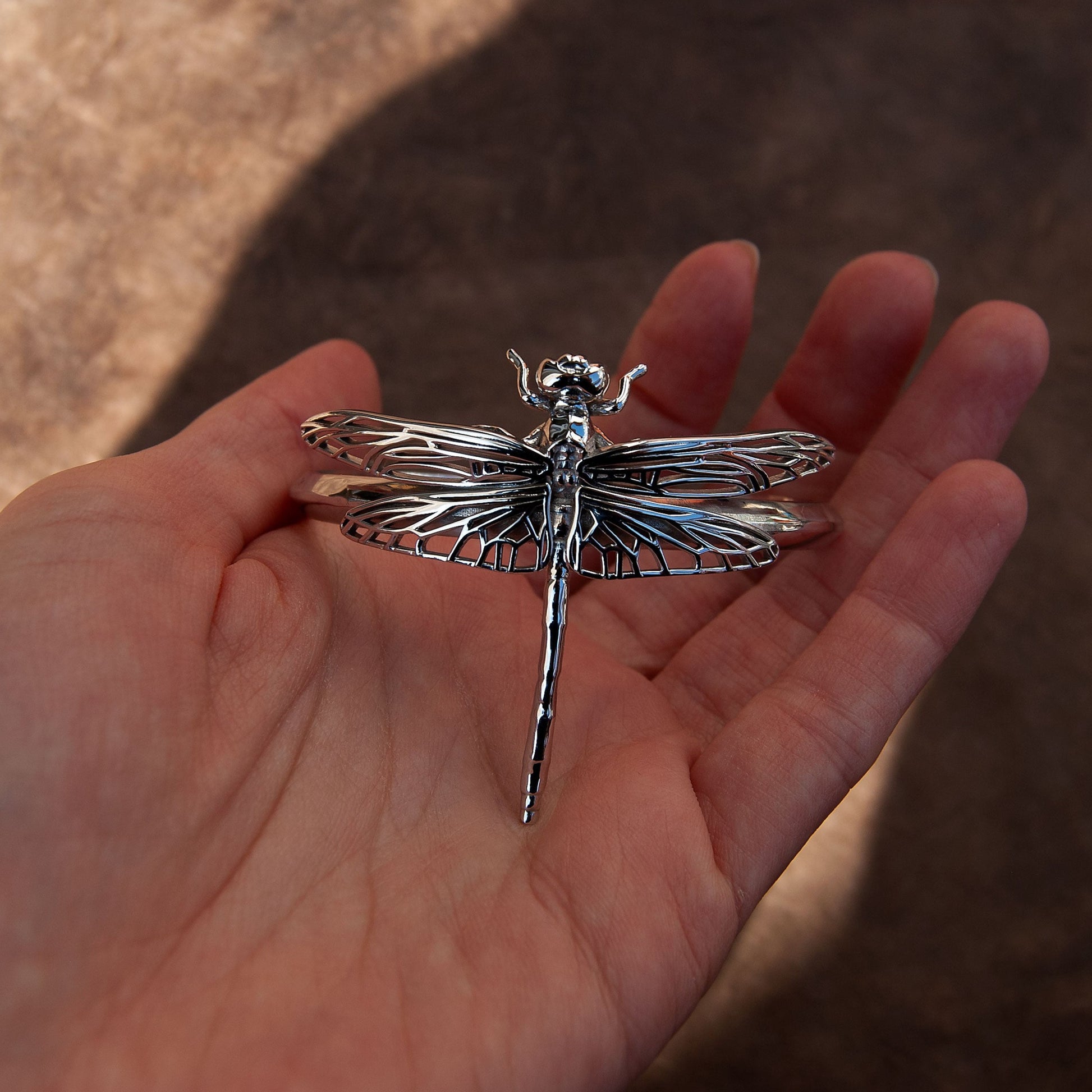 Closeup of Silver Dragonfly Bracelet, highlighting intricate wing cut-outs and sculptural detail.