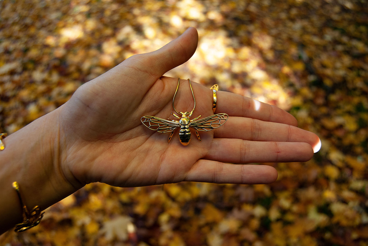 handmade bee pendant necklace with natural background
