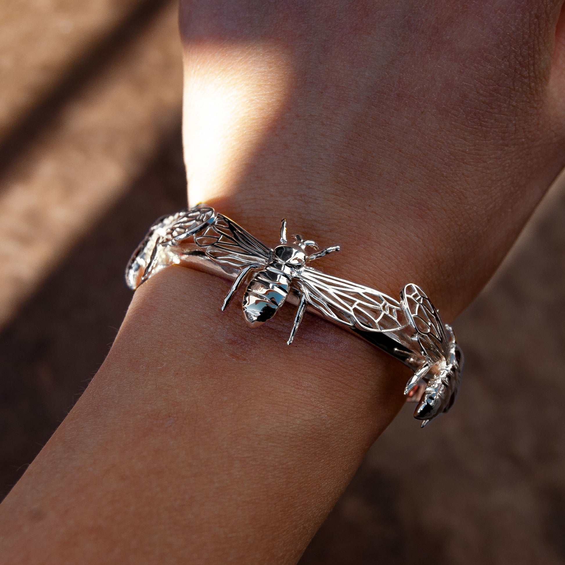 Silver bee cuff bracelet worn on wrist, showcasing elegant fit and fine detail